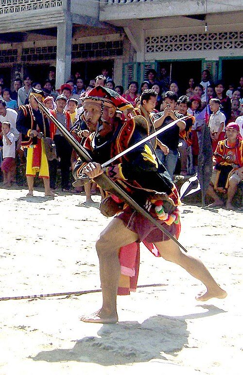 A man holding a Balato (sword) in a Nias war dance.