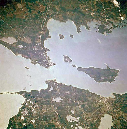 Mackinac Island is the top-left island of the three islands just to the east (right) of the Straits of Mackinac.